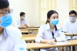 Các thí sinh đeo khẩu trang khi làm bài thi tại điểm trường THCS Đống Đa (Hà Nội). (Ảnh: Thành Đạt/TTXVN)