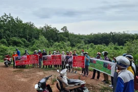 Người dân căng băngrôn, phát loa để đòi tiền đã mua đất trước đó tại dự án An Điền. (Ảnh: TTXVN)