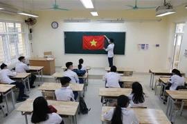 Học sinh Trường THPT Trần Nhân Tông, quận Hai Bà Trưng chuẩn bị lễ chào cờ đầu tuần. (Ảnh: Thanh Tùng/TTXVN)