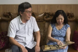 Hai nhà báo, phóng viên chiến trường Hồ Phước Huề và Triệu Thị Thùy ôn lại kỷ niệm những tháng ngày tác nghiệp tại chiến trường. (Ảnh: Quốc Dũng/TTXVN)