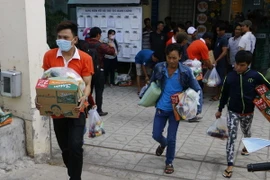 Công nhân Công ty Kwong Lung-Meko nhận quà hỗ trợ. (Ảnh: Thanh Liêm/TTXVN)