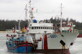 Tàu Cảnh sát biển 6001 lai dắt tàu cá KH 94888TS vào bờ. (Ảnh: Đỗ Trưởng/TTXVN)