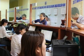 Người dân đến làm thủ tục tại bộ phận một cửa Văn phòng Đăng ký đất đai Hà Nội. (Ảnh: Đỗ Phương Anh/TTXVN)