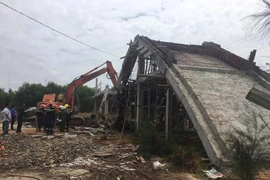 Lực lượng chức năng khẩn trương tháo dỡ phần giàn giáo bêtông bị sập để tìm kiếm nạn nhân có thể còn bị vùi phía dưới. (Ảnh: Đoàn Mạnh Dương/TTXVN)