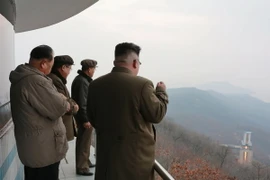 Nhà lãnh đạo Triều Tiên Kim Jong-un (phải) theo dõi việc thử động cơ tên lửa tại một địa điểm bí mật. (Nguồn: EPA/TTXVN)