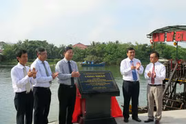 Gắn biển công trình kè bảo vệ khu đô thị cổ Hội An tại buổi lễ. (Ảnh: Nguyễn Sơn/TTXVN)