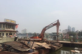 Lượng chức năng tiến hành tháo dỡ bến nổi, nhà chờ khu vực từ số 2 phố Nguyễn Đình Thi. (Ảnh: Nguyễn Thắng/TTXVN)