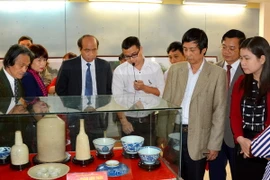 Các đại biểu tham quan và tìm hiểu những cổ vật quý tại buổi trưng bày. (Ảnh: Tạ Toàn/TTXVN)