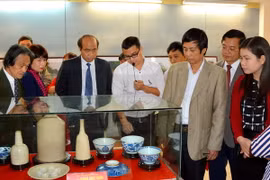 Các đại biểu tham quan và tìm hiểu những cổ vật quý tại buổi trưng bày. (Ảnh: Tạ Toàn/TTXVN)