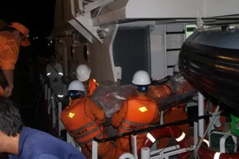 Đưa thi thể Thuyền phó Lương Văn Quỳnh về bờ. (Ảnh: Đoàn Mạnh Dương/TTXVN)