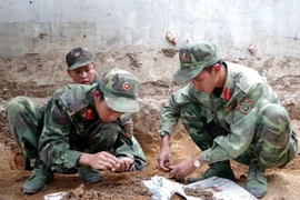 Các chiến sỹ đang tìm kiếm hài cốt. (Ảnh: Cao Nguyên/TTXVN)