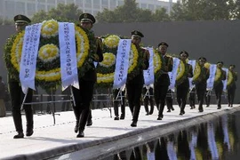 Binh sĩ Trung Quốc đặt hoa tại lễ tưởng niệm các nạn nhân vụ thảm sát Nam Kinh tại Bảo tàng tưởng niệm cuộc thảm sát Nam Kinh. THX-TTXVN