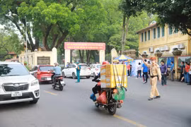 Cảnh sát giao thông phân luồng phương tiện trước cổng Trường Trung học Phổ thông Chu Văn An. (Ảnh: Hoài Nam/Vietnam+)
