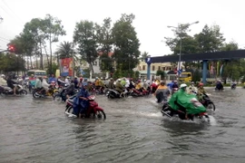 Đoạn giao nhau giữa đường Phan Ngọc Hiển và Trần Hưng Đạo (Cà Mau) bị ngập sâu gây khó khăn cho việc lưu thông của người và phương tiện. (Ảnh: Kim Há/TTXVN)