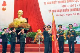 Thượng tướng Đỗ Bá Tỵ gắn Huân chương Bảo vệ Tổ quốc hạng Nhì lên Cờ truyền thống của Cục Quân lực. (Ảnh: Trọng Đức/TTXVN)