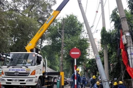 Công nhân Công ty Điện lực TP. Hồ Chí Minh đang khẩn trương khắc phục sự cố. (Ảnh: An Hiếu/TTXVN)