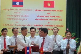Đại diện lãnh đạo Sở Thông tin và Truyền thông tỉnh Quảng Bình và Sở Bưu điện, Viễn thông và Thông tin tỉnh Khammouane (Lào) trao Biên bản ghi nhớ hợp tác. (Ảnh: Dung Dung/TTXVN)