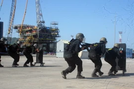 Diễn tập tình huống lực lượng chống khủng bố triển khai đội hình áp sát khu vực giam giữ con tin. (Ảnh: Đoàn Mạnh Dương/TTXVN)