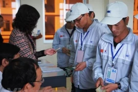 Lao động làm thủ tục đi Hàn Quốc làm việc. (Ảnh: PV/Vietnam+)