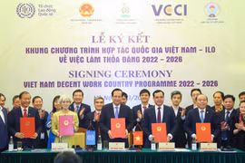 Ký kết Khung Chương trình Quốc gia Việc làm thỏa đáng của Việt Nam giai đoạn 2022-2026. (Ảnh: PV/Vietnam+)