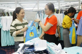 Trao quà hỗ trợ cho công nhân bị giảm giờ làm, giảm thu nhập. (Ảnh: Thanh Vũ/TTXVN)