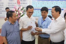 Trao giấy khai sinh và thẻ bảo hiểm y tế theo dịch vụ công liên thông. (Ảnh: PV/Vietnam+)