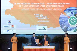 Ông Nguyễn Thanh Tùng - Phó Tổng Giám đốc phụ trách Ban điều hành Vietcombank (bên trái) và ông Đồng Văn Thanh - Chủ tịch UBND tỉnh Hậu Giang ký kết biên bản thỏa thuận hợp tác. (Ảnh: Vietnam+)