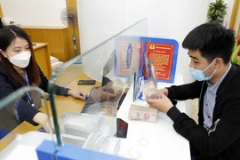 Giao dịch tại ngân hàng. (Ảnh: TTXVN)