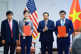 Bà Stephanie von Friedeburg - Phó Chủ tịch điều hành cao cấp IFC (thứ 2 từ trái sang) và ông Trần Hoài Nam - Phó Tổng giám đốc HDBank (bìa phải) trao văn kiện ký kết dưới sự chứng kiến của Thủ tướng Chính phủ Phạm Minh Chính. (Ảnh: Vietnam+)