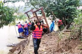 Lực lượng biên phòng cùng cán bộ giáo viên và nhân dân tại xã Trường Sơn, huyện Quảng Ninh, Quảng Bình di dời bàn ghế, vật dụng dạy học lên nơi cao ráo. (Ảnh: Võ Dung/TTXVN) 