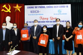 Ông Cho Han-Deok, Giám đốc quốc gia KOICA Việt Nam (thứ tư từ trái sang) trao quà cho phụ nữ có hoàn cảnh khó khăn tại Hà Nội. Ảnh: TTXVN