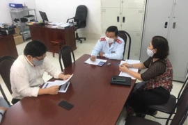 Trong ảnh: Đối tượng N.T. H (đeo kính ngồi bên trái) làm việc với Thanh tra Sở Thông tin và Truyền thông thành phố Cần Thơ. Ảnh: TTXVN phát