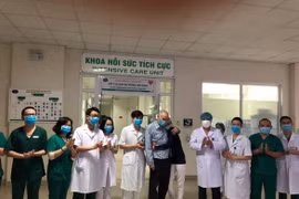 Vợ chồng ông Dixong (mặc áo bệnh nhân/áo đen) và các nhân viên y tế Bệnh viện Bệnh nhiệt đới trung ương tối 13-4, trước khi ông bà ra viện và về nước. (Ảnh: Bệnh viện Bệnh Nhiệt đới Trung ương cung cấp)