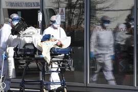 Nhân viên y tế tại Pháp đưa người nhiệm bệnh vào viện. (Ảnh: France24)