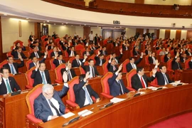 Các đồng chí lãnh đạo Đảng, Nhà nước và các đại biểu biểu quyết thông qua Nghị quyết Hội nghị Trung ương lần thứ mười hai. (Ảnh: Trí Dũng/TTXVN)