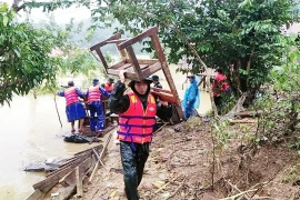 Lực lượng biên phòng cùng cán bộ giáo viên và nhân dân tại xã Trường Sơn, huyện Quảng Ninh, Quảng Bình di dời bàn ghế, vật dụng dạy học lên nơi cao ráo. (Ảnh: Võ Dung/TTXVN) 