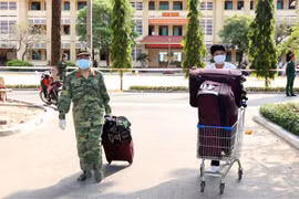 Các chiến sỹ trường Quân sự Quân khu 7 hỗ trợ vận chuyển đồ cho công dân đã hoàn thành xong thời gian cách ly y tế. (Ảnh: Xuân Khu/TTXVN)
