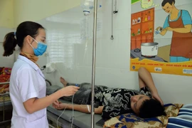 Nhân viên y tế tại Trạm Y tế xã Chiềng Cọ điều trị cho các học sinh nghi ngộ độc thực phẩm. (Ảnh: TTXVN)