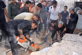 Lực lượng cứu trợ Syria tìm kiếm người sống sót trong đống đổ nát sau vụ pháo kích vào quận Hamdaniyeh, thành phố Allepo ngày 4/6. (Nguồn: AFP/TTXVN)