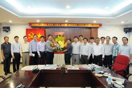 Bí thư Thành ủy TP. Hồ Chí Minh Đinh La Thăng tặng hoa chúc mừng các cán bộ, phóng viên cơ quan TTXVN khu vực phía Nam. (Ảnh: An Hiếu/TTXVN)