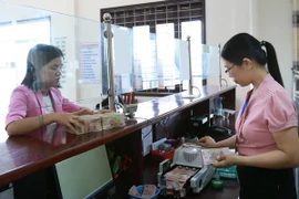 Khách hàng giao dịch tại Kho bạc Nhà nước huyện Cam Lộ, tỉnh Quảng Trị. (Ảnh: Hoàng Hùng/TTXVN)