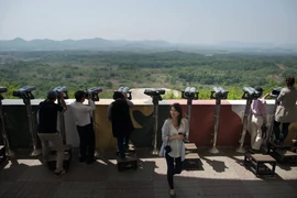 Khách du lịch ngắm phong cảnh qua đài quan sát gần khu phi quân sự Panmunjom giữa Hàn Quốc và Triều Tiên ngày 14/5. (Nguồn: AFP/TTXVN)