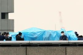 Cảnh sát kiểm tra vật thể bay được phát hiện trên nóc Văn phòng Thủ tướng Nhật. (Ảnh: AFP/TTXVN phát)