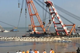 Hệ thống cần trục được triển khai để trục vớt tàu chìm (giữa) trên sông Dương Tử ngày 5/6. (Nguồn: AFP/TTXVN)