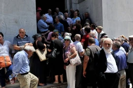 Người dân xếp hàng chờ rút tiền bên ngoài chi nhánh Ngân hàng quốc gia Hy Lạp đã đóng cửa ở Thessaloniki ngày 29/6. (Nguồn: AFP/TTXVN)