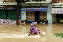 Đường Hùng Vương, thành phố Quy Nhơn bị ngập sâu, giao thông đi lại rất khó khăn. (Ảnh: Nguyên Linh/TTXVN)