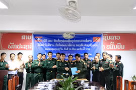 Đại diện Bộ Tư lệnh Thông tin liên lạc, Bộ Quốc phòng Việt Nam (trái) và Đại tá Sayaphon Chanthavong (phải), Cục trưởng Cục trưởng Cục Thông tin, Bộ Tổng tham mưu Quân đội Nhân dân Lào, đang trao cho nhau Biên bản bàn giao trang thiết bị tại buổi lễ. (Ảnh