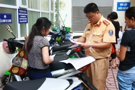 Công an quận Hai Bà Trưng, Hà Nội làm thủ tục đăng ký đăng ký xe môtô điện, xe máy điện cho nhân dân trước ngày 1/7/2016. (Ảnh: Doãn Tấn/TTXVN)