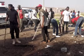 Người dân dọn dẹp hiện trường sau vụ tấn công ở Maiduguri ngày 29/10. (Nguồn: AP/TTXVN)