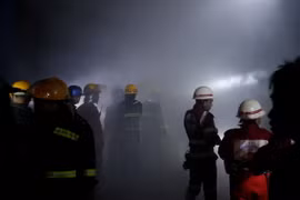 Lính cứu hỏa làm nhiệm vụ tại hiện trường vụ nổ trên phố Tharyar rạng sáng 21/11. (Nguồn: EPA/TTXVN)